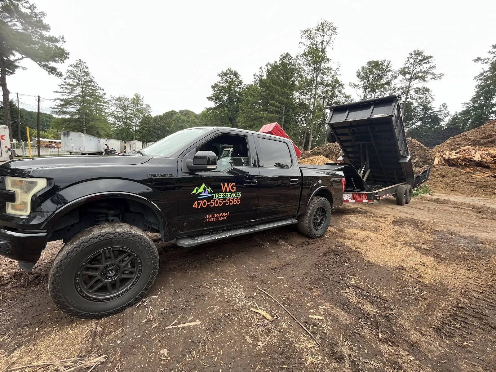 The branded black WG Treeservices truck and dump trailer at a metro Atlanta job site.